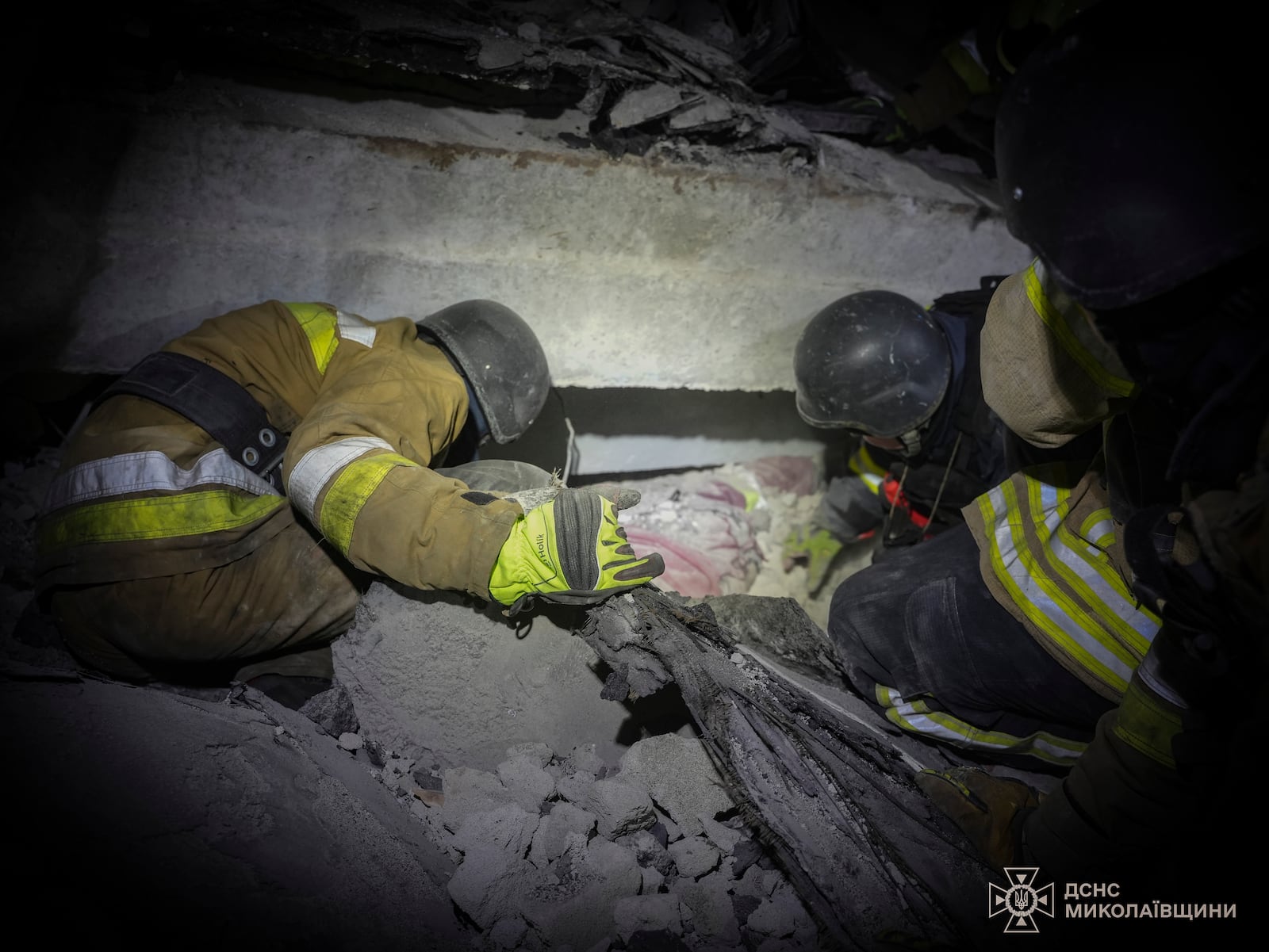 In this photo provided by the Ukrainian Emergency Service, rescuers unblock the body of a civilian who was killed when a Russian drone hit a city food factory in Mykolaiv, Ukraine, Wednesday, Jan. 29, 2025. (Ukrainian Emergency Service via AP)