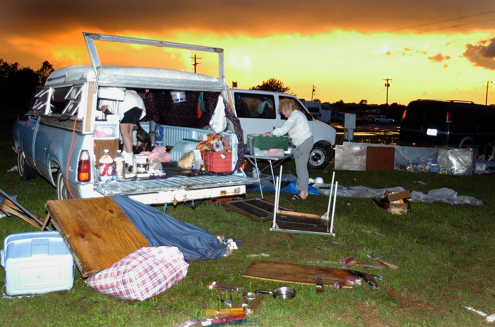 FILE - Lois Wasson, of Clinton, La., boxes up debris after a powerful thunderstorm struck the Marlow, Okla., flea market, June 4, 2005. (Jeff Dixon/The Lawton Constitution via AP, File)