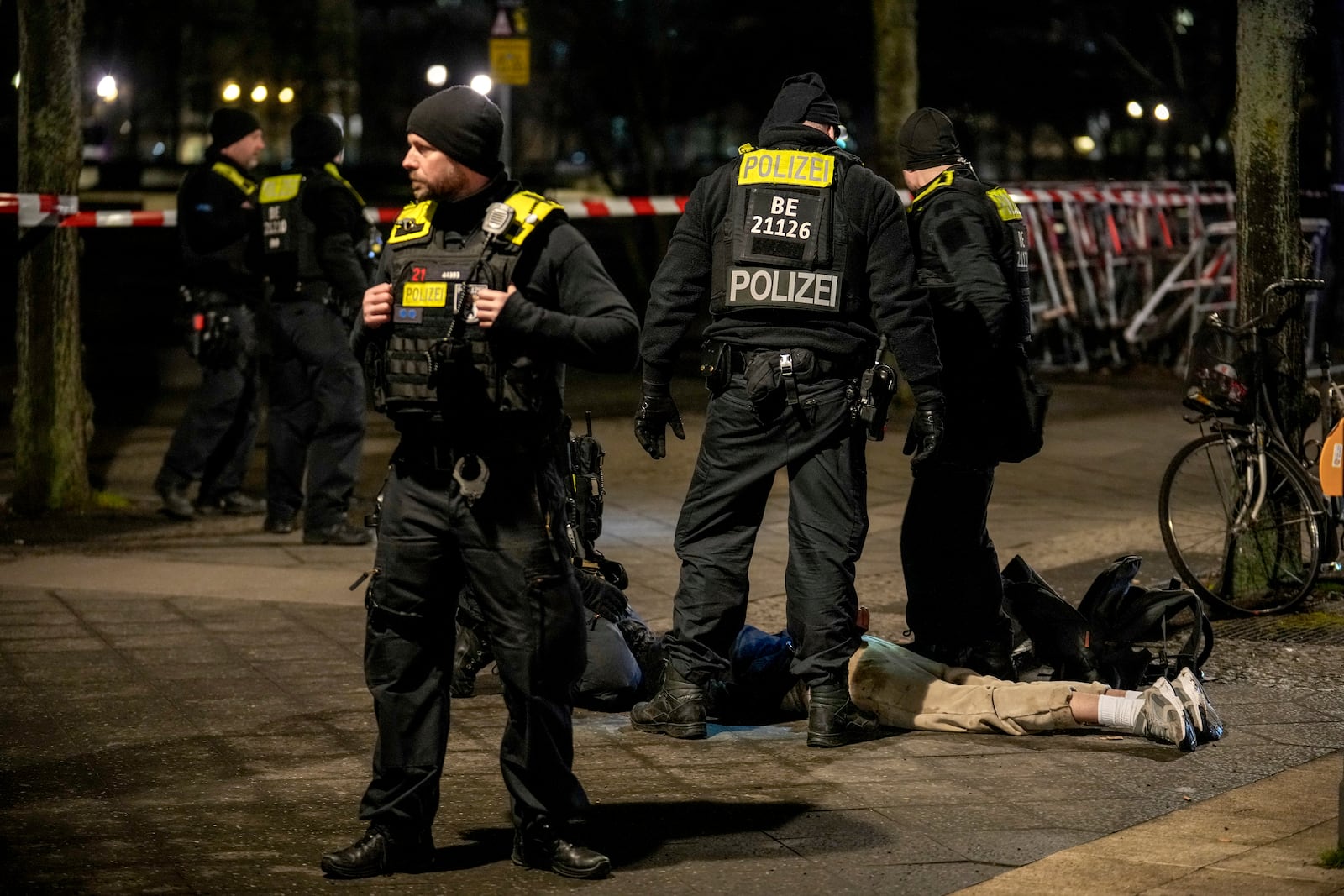 Police officers detain a man at the Holocaust memorial in Berlin, Germany, after another man was seriously injured, Friday, Feb. 21, 2025. (AP Photo/Ebrahim Noroozi)