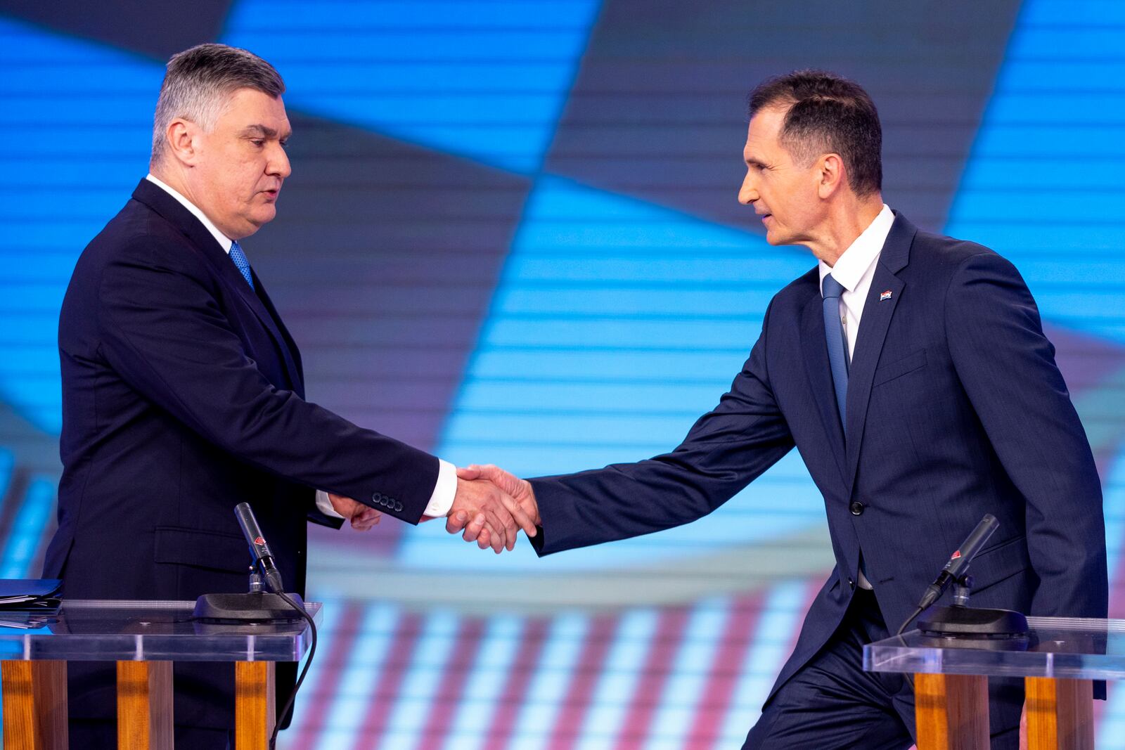 Croatian Presidential candidate Dragan Primorac, right, shakes hands with President incumbent Zoran Milanovic before a TV debate, ahead of the run-off of the Croatian presidential election, in Zagreb, Croatia, Tuesday, Jan. 7, 2025. (Damir Sencar/Pool Photo via AP)