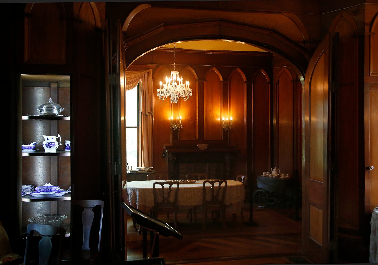 A chandelier illuminates the oak and walnut raised panels surrounding the dining room and parquet floors shine at Mac-A-Cheek, a home built by Abram Sanders Piatt and one of the Piatt Castles of Logan County. LISA POWELL / STAFF