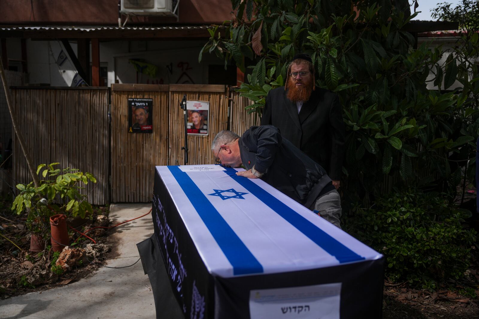 Danny Elgarat, kisses coffin of his brother, Itzhak Elgarat, a slain hostage who was held captive by Hamas in Gaza, during his funeral procession in Kibbutz Nir Oz, Israel, on Monday, March 3, 2025. (AP Photo/Ohad Zwigenberg)