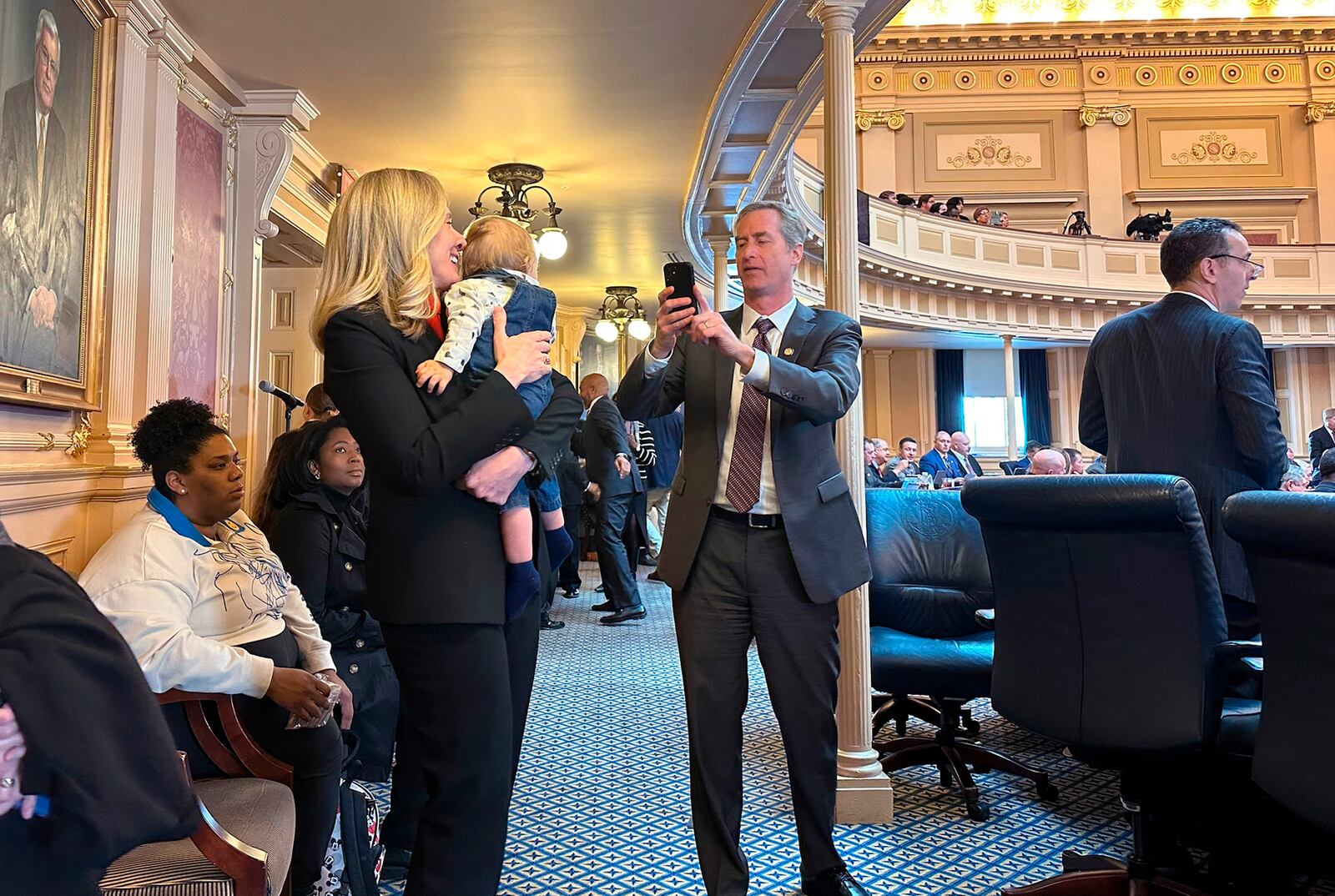 Former Rep Abigail Spanberger holds Michael Groves Jr., the nephew of Virginia Del. Joshua Cole, while posing for a photo taken by Virginia Del. David Bulova, at the state Capitol, Jan. 14, 2025, in Richmond, Va (AP Photo/Olivia Diaz)