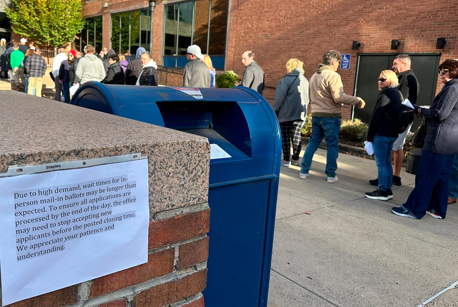 People wait in line outside the Bucks County government building to apply for an on-demand mail ballot on the last day to request one in Doylestown, Pa., Tuesday, Oct. 29, 2024. (AP Photo/Mike Catalini)