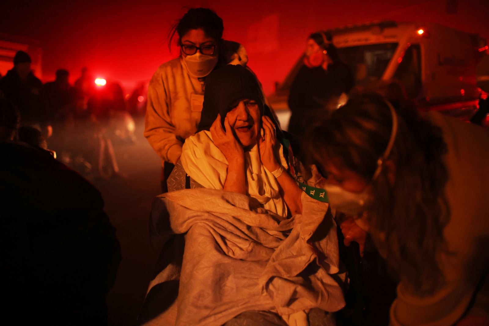 A resident of a senior center is evacuated as the Eaton Fire approaches Tuesday, Jan. 7, 2025 in Altadena, Calif. (AP Photo/Ethan Swope)