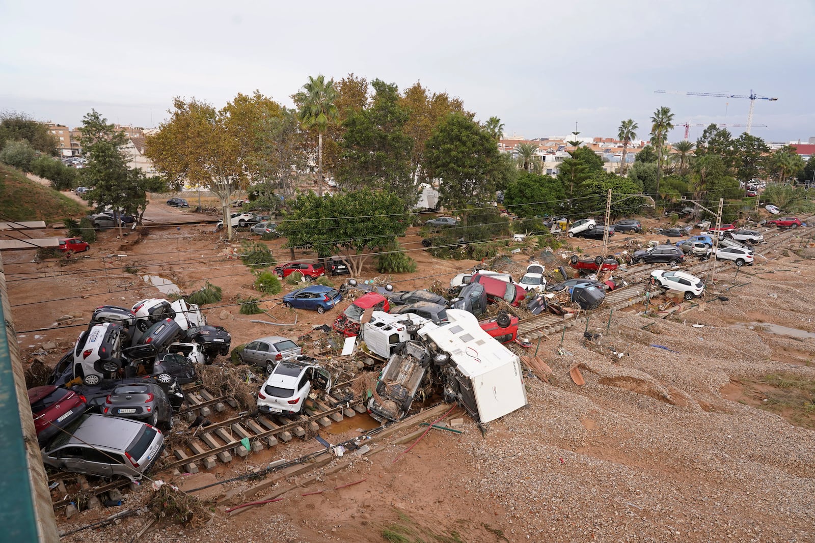 Vehicles are strewn across railway tracks after floods on the outskirts of Valencia, Spain, Friday, Nov. 1, 2024. (AP Photo/Alberto Saiz)