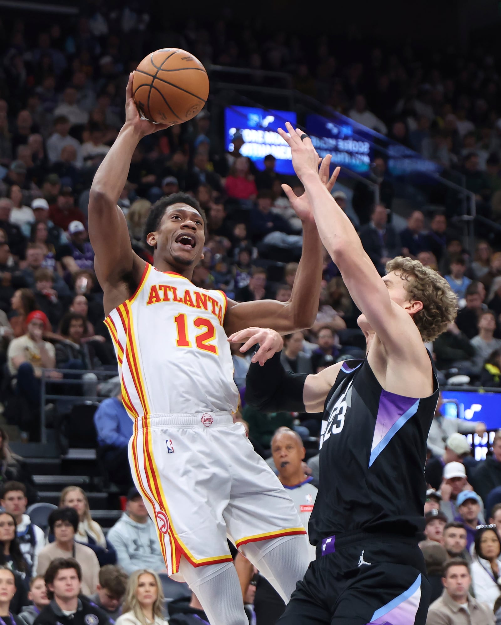 Atlanta Hawks forward De'Andre Hunter (12) shoots against Utah Jazz forward Lauri Markkanen (23) during the first quarter of an NBA basketball game, Tuesday, Jan. 7, 2025, in Salt Lake City. (AP Photo/Rob Gray)