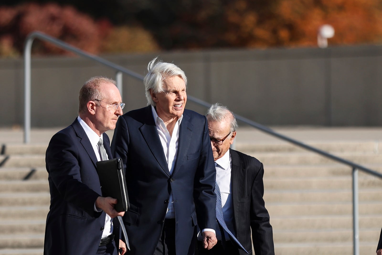 Michael Jeffries, former CEO of Abercrombie & Fitch, center, exits the federal courthouse after his arraignment on sex trafficking and interstate prostitution charges, Friday, Oct. 25, 2024, in Central Islip, N.Y. (AP Photo/Heather Khalifa)