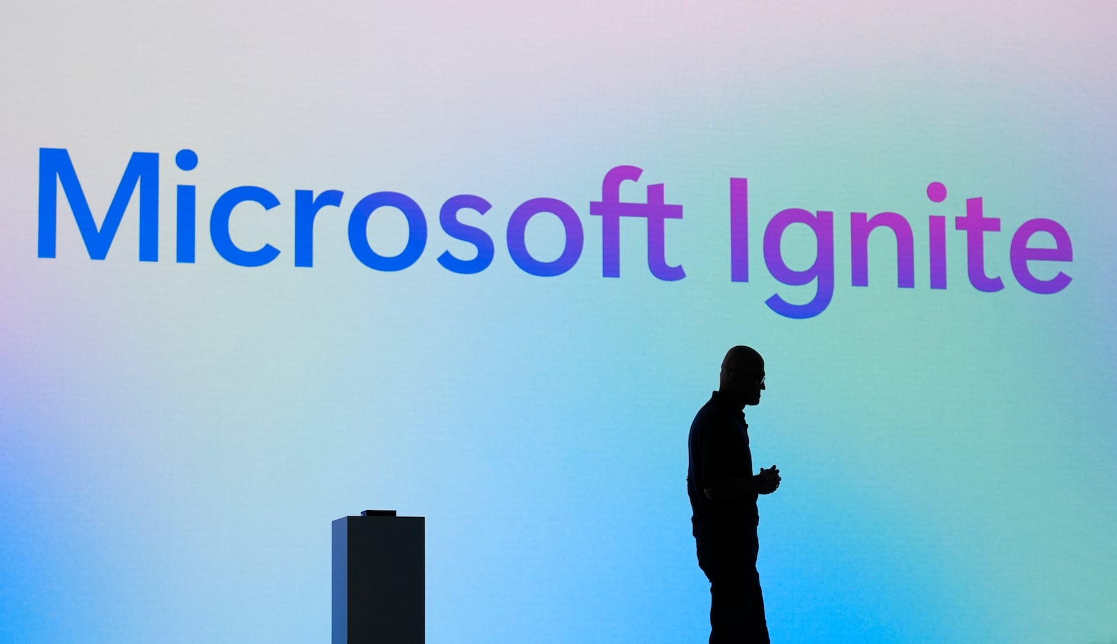 Microsoft CEO Satya Nadella stands in silhouette during the Microsoft Ignite conference Tuesday, Nov. 19, 2024, in Chicago. (AP Photo/Charles Rex Arbogast)