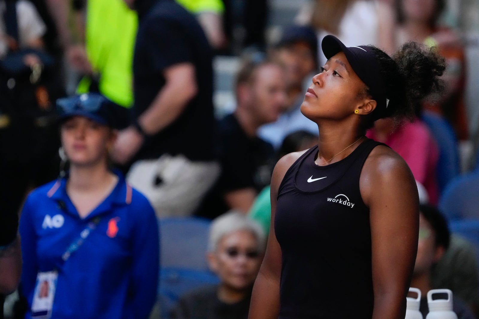 Naomi Osaka of Japan reacts as she retires from her third round match against Belinda Bencic of Switzerland at the Australian Open tennis championship in Melbourne, Australia, Friday, Jan. 17, 2025. (AP Photo/Manish Swarup)