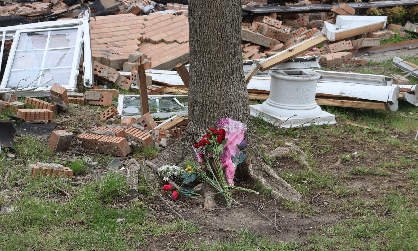 Flowers were laid at the base of a tree in front of a townhome on Home Road that exploded April 8, killing two women and injuring a baby.