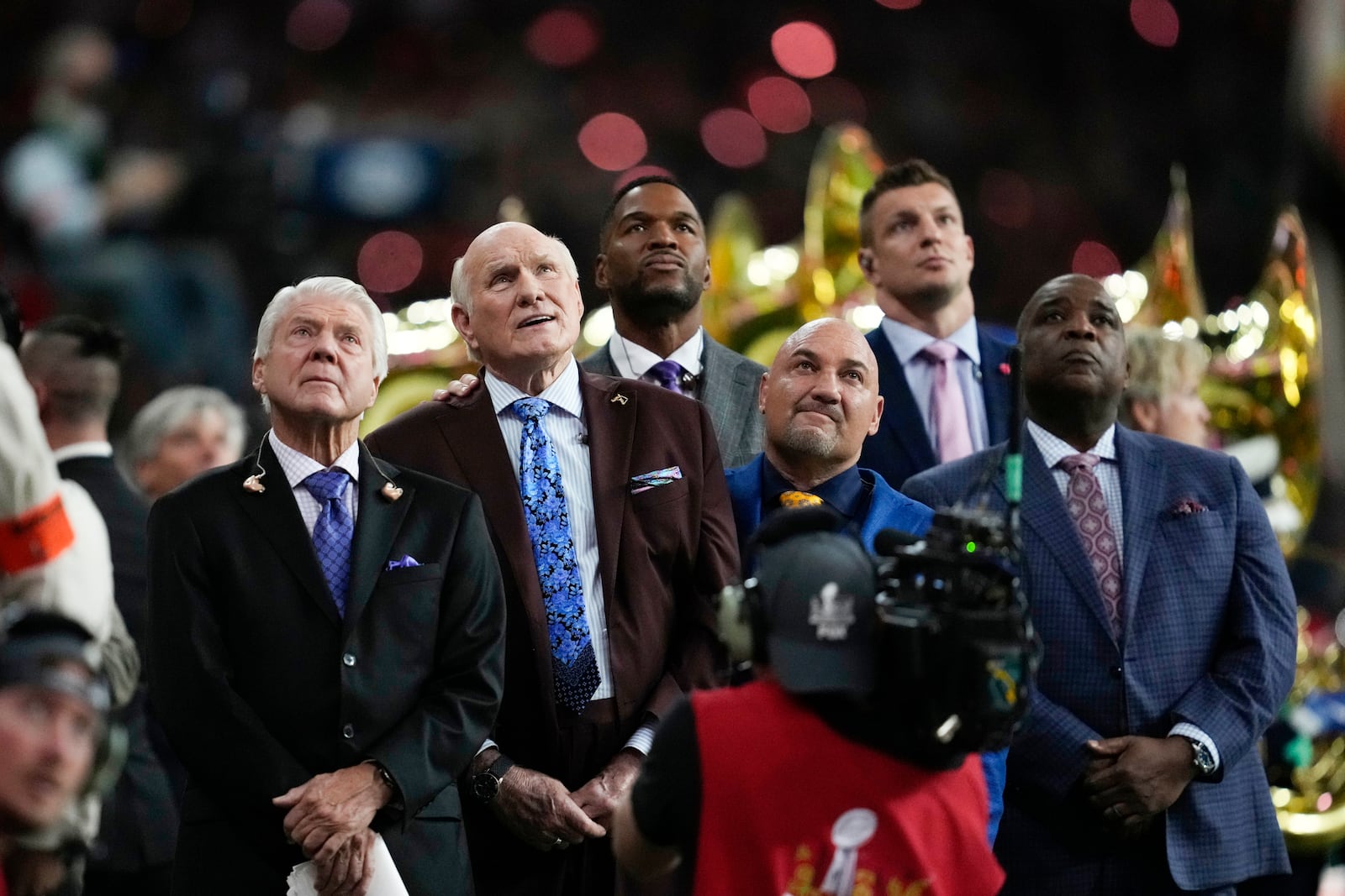 Jimmy Johnson, left, Terry Bradshaw, second from left, Rob Gronkowski, back right, and Michael Strahan watch a performance on a screen ahead of the NFL Super Bowl 59 football game between the Kansas City Chiefs and the Philadelphia Eagles, Sunday, Feb. 9, 2025, in New Orleans. (AP Photo/Ashley Landis)