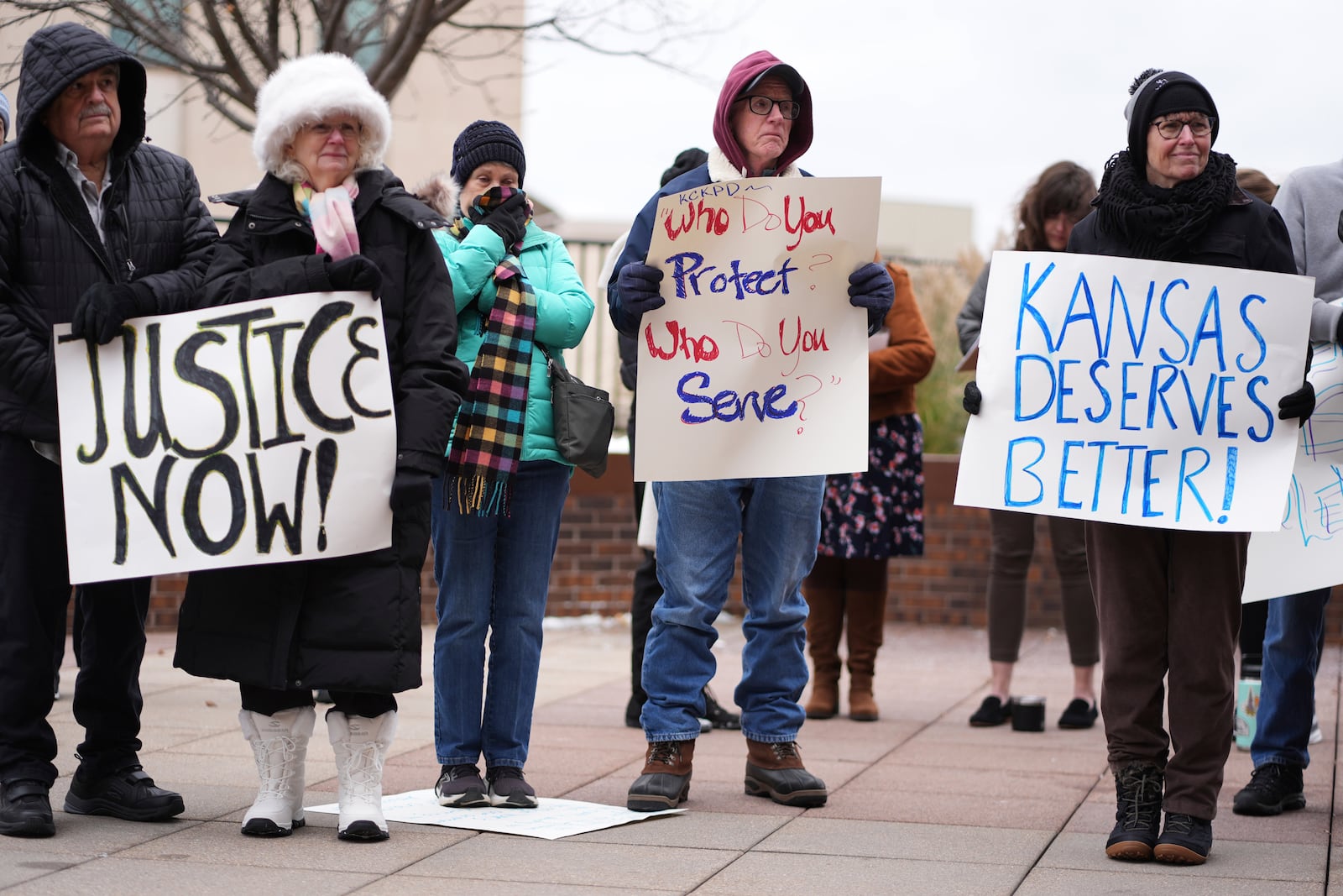 People listen to a speaker at a rally outside the federal courthouse on was was to be the opening day for a trial for former police detective Roger Golubski, Monday, Dec. 2, 2024, in Topeka, Kan. (AP Photo/Charlie Riedel)