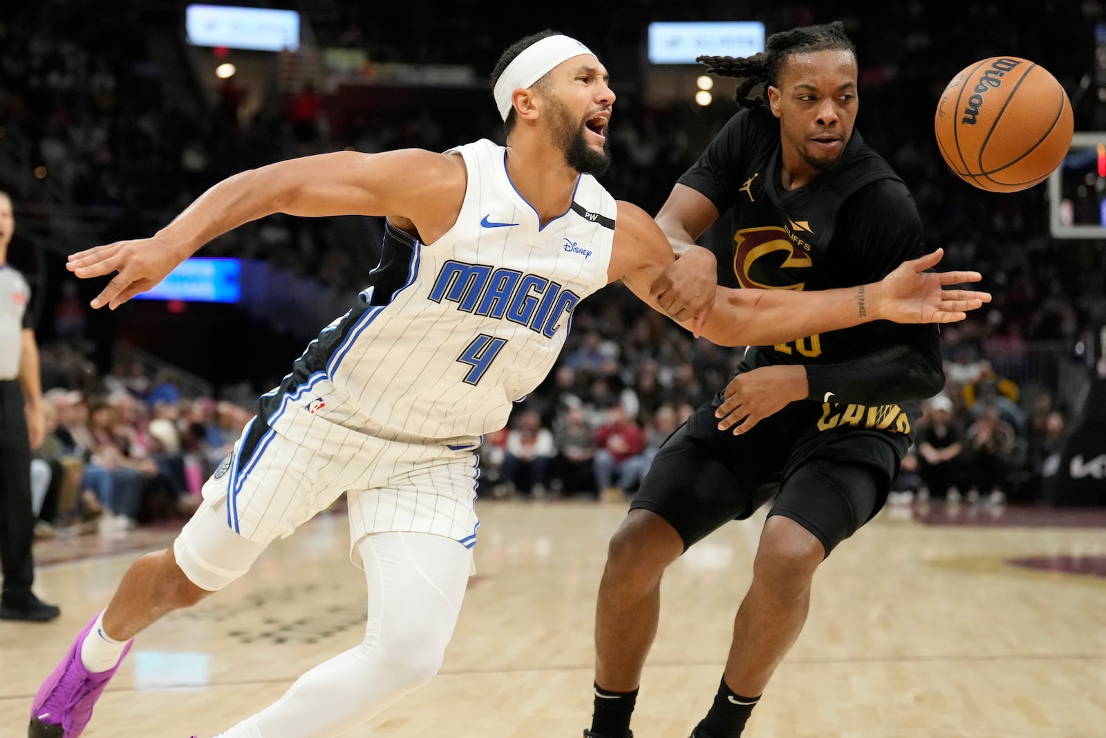 Orlando Magic guard Jalen Suggs (4) is fouled by Cleveland Cavaliers guard Darius Garland, right, in the first half of an NBA basketball game, Friday, Nov. 1, 2024, in Cleveland. (AP PhotoSue Ogrocki)