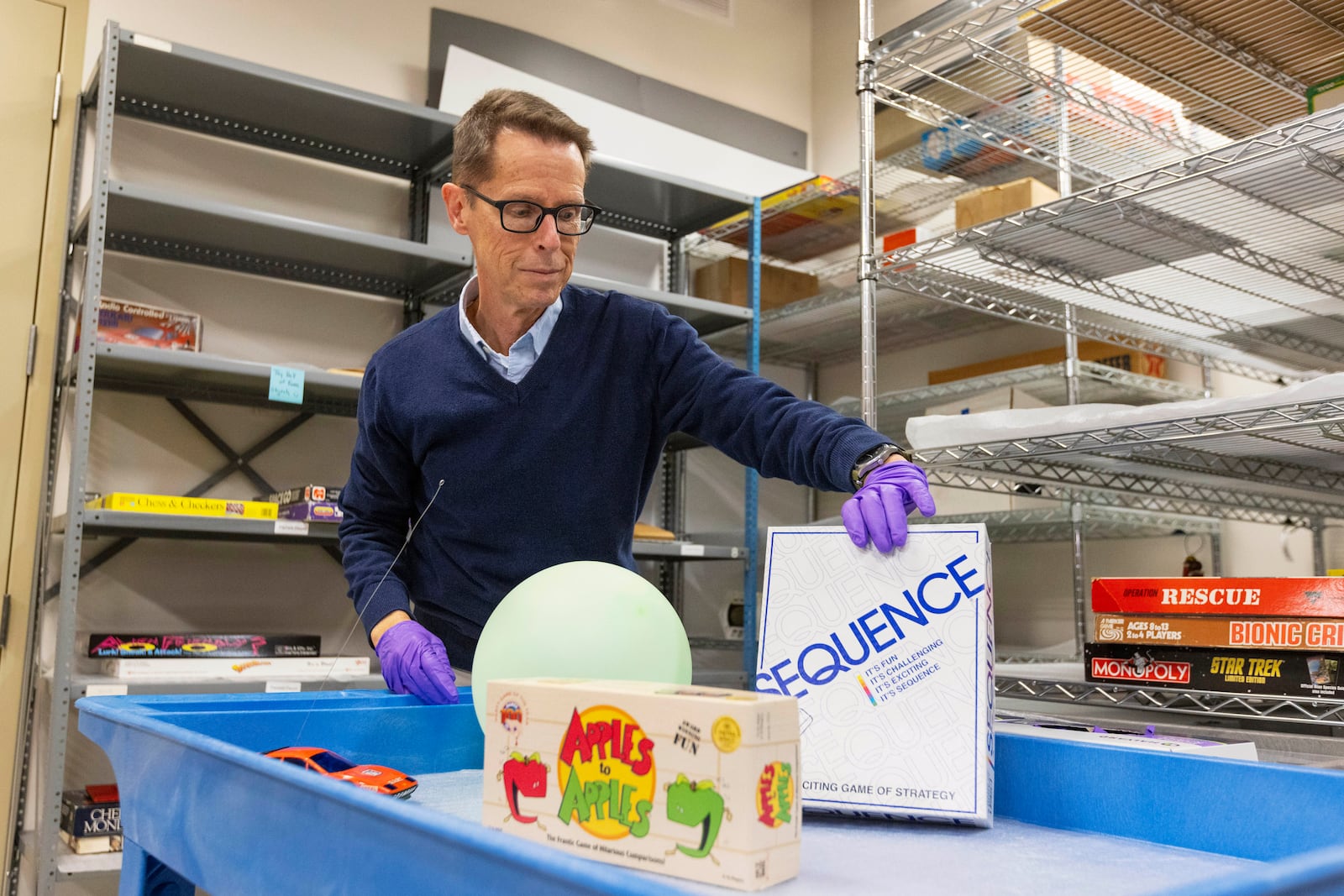 Christopher Bensch, chief curator at The Strong National Museum of Play, takes out toys and games that are finalists for the 2024 Hall of Fame, Tuesday, Oct. 15, 2024, in Rochester, N.Y. (AP Photo/Lauren Petracca)