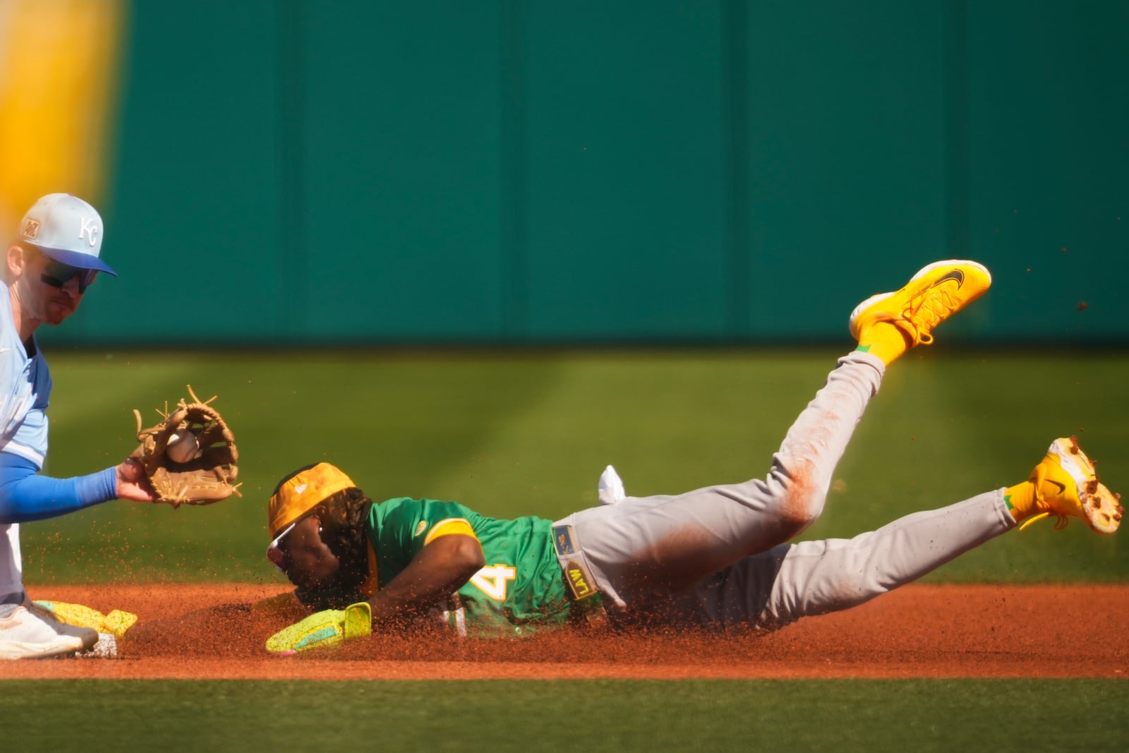 Athletics' Lawrence Butler, right, is tagged out trying to steal second base by Kansas City Royals shortstop Cam Devanney in the first inning during a spring training baseball game Monday, Feb. 24, 2025, in Surprise, Ariz. (AP Photo/Lindsey Wasson)