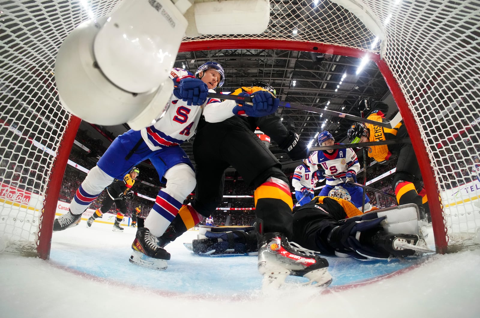 Germany goaltender Nico Pertuch, bottom right, defends his net as a United States player battles for the puck during second-period IIHF World Junior Hockey Championship preliminary round game action in Ottawa, Ontario, Thursday, Dec. 26, 2024. (Sean Kilpatrick/The Canadian Press via AP)