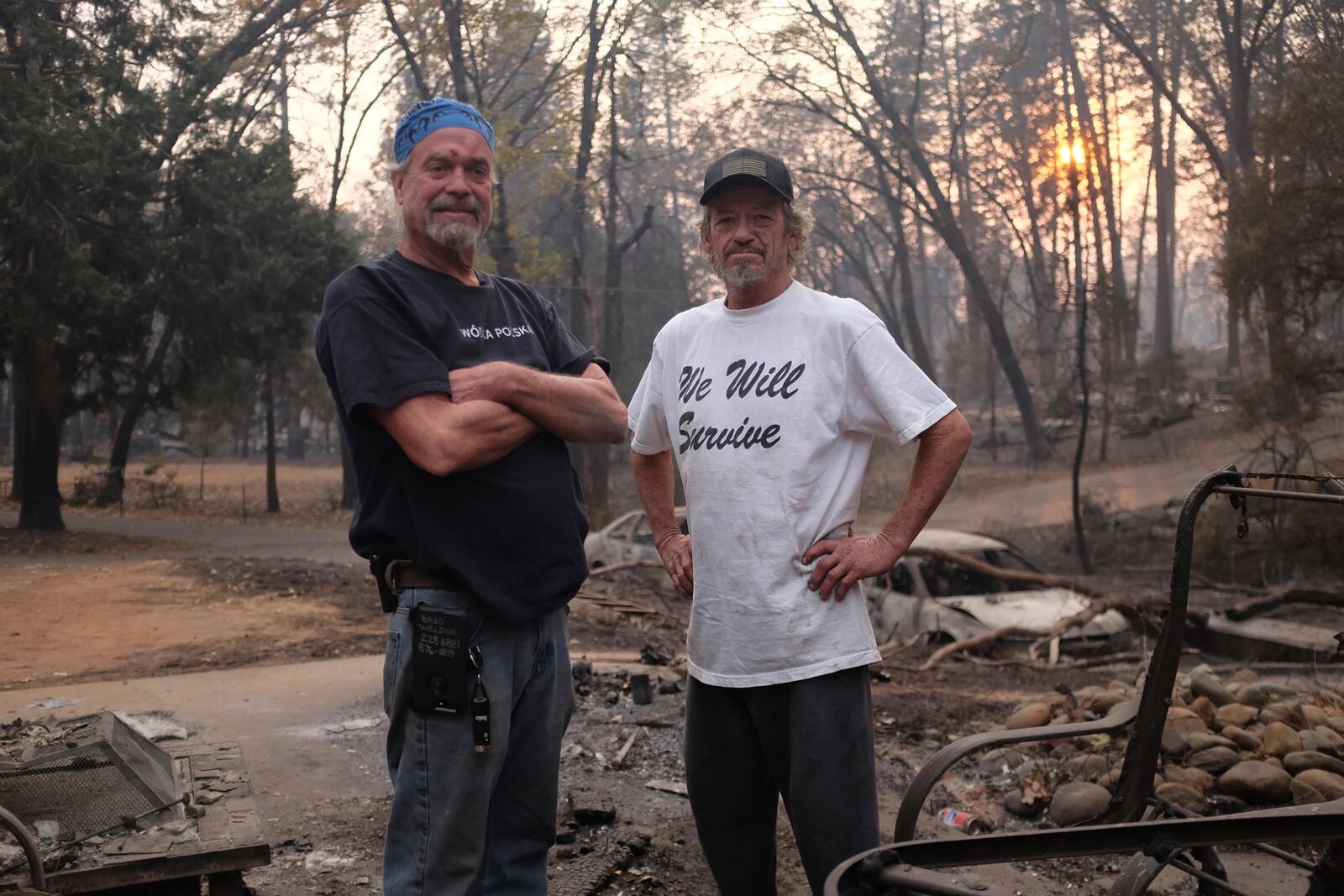 Brad Weldon, left, and Lyndon McAfee pose among the destruction from the wildfire in Paradise, Calif., on Nov. 19, 2018, during the filming of the documentary "Bring Your Own Brigade." (Lucy Walker via AP)