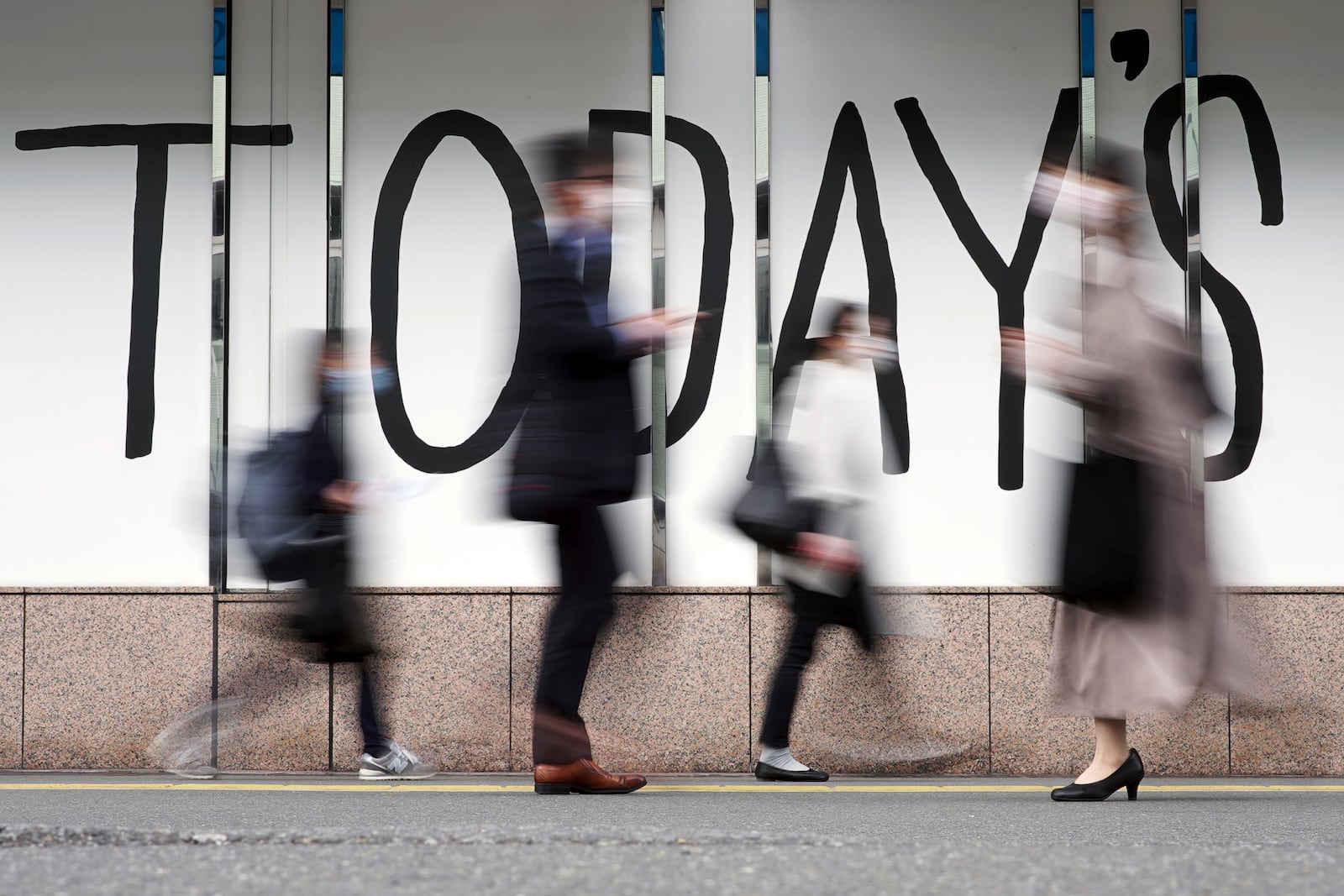 FILE - People wearing face masks walk along a street April 7, 2022, in Tokyo. (AP Photo/Eugene Hoshiko, File)