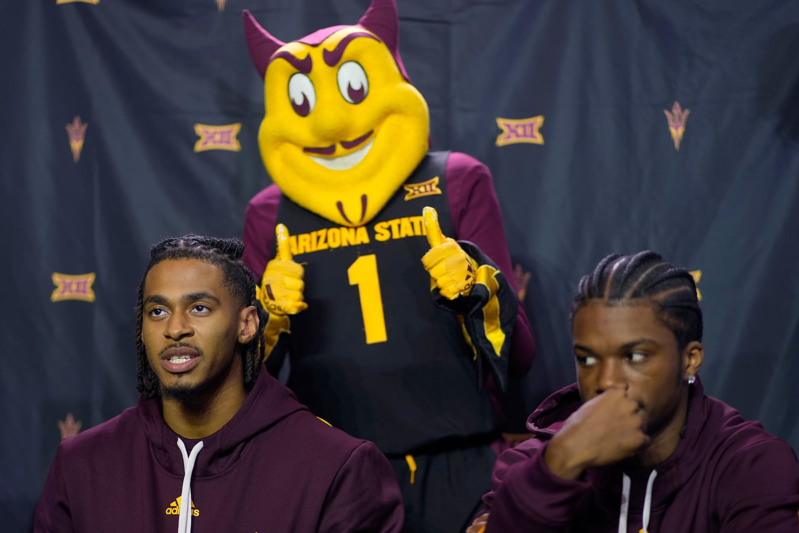 Arizona State's Adam Miller, left, talks to the media during the NCAA college Big 12 men's basketball media day, Wednesday, Oct. 23, 2024, in Kansas City, Mo. (AP Photo/Charlie Riedel)