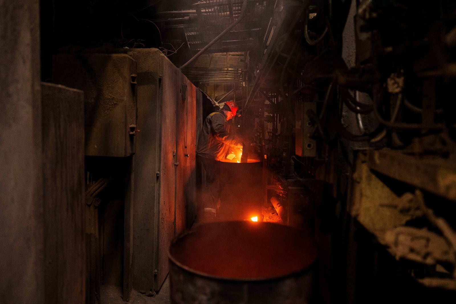 A worker throws firewood into a stove to heat pipes at DTEK's power plant after a recent Russian missile attack in Ukraine, Nov. 28, 2024. (AP Photo/Evgeniy Maloletka)