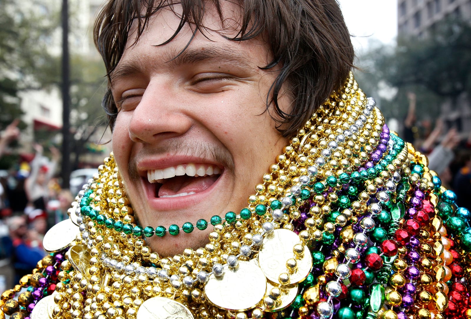 FILE - Lee Chance laughs as he shows off his collection of beads that he caught during the Zulu Social Aid and Pleasure Club parade in New Orleans on Mardi Gras Day, March 8, 2011. (AP Photo/Patrick Semansky, File)