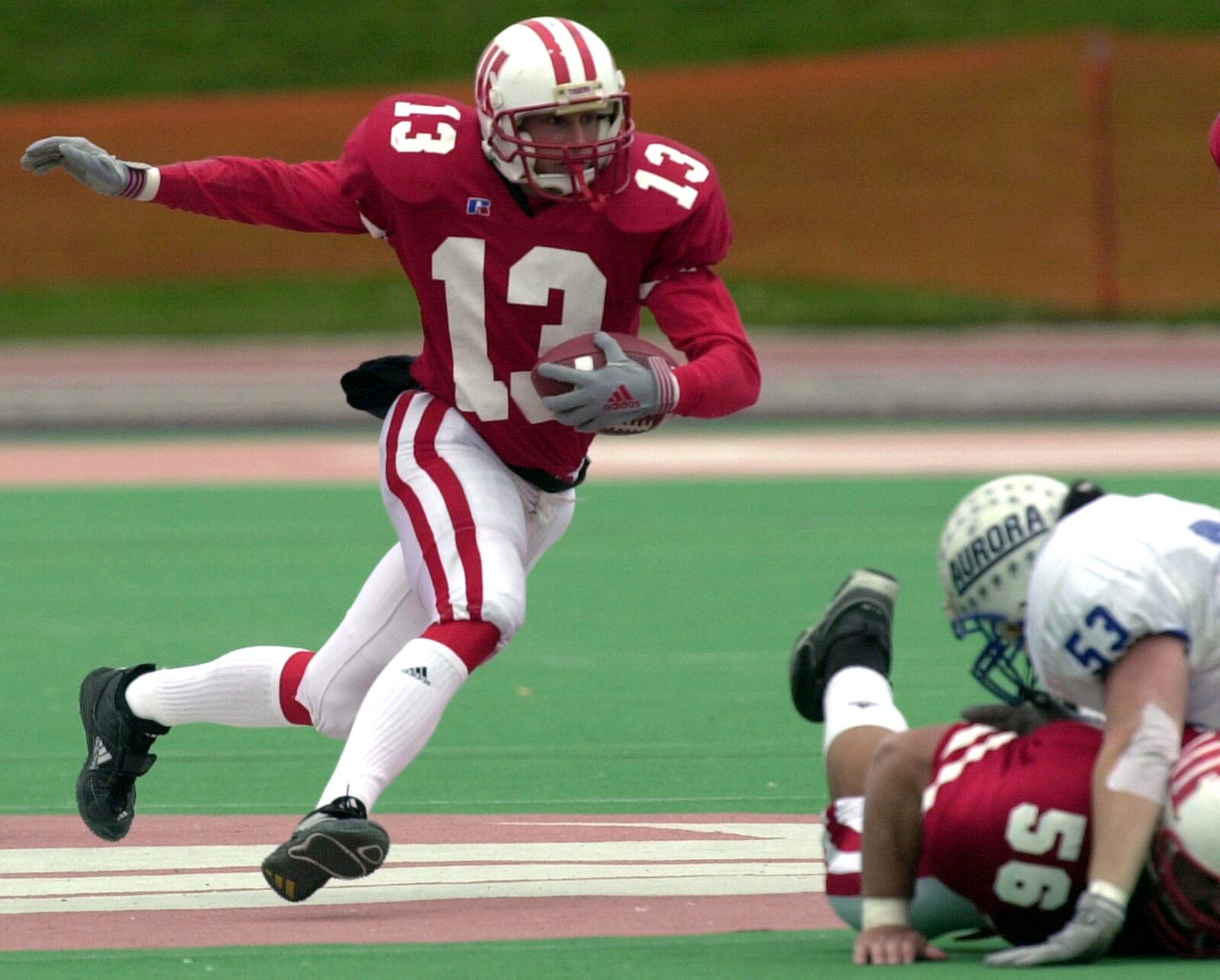 Wittenberg's Michael Aljancic (13) carries the ball up field as Wittenberg lineman Nick Long (56) blocks Aurora's Jason Nawracaj (53) during their Division III play-off game in 2000.