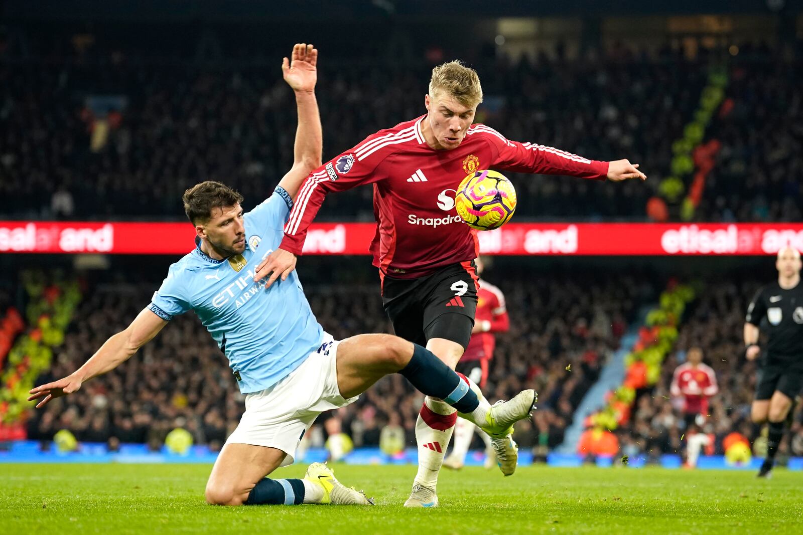 Manchester City's Ruben Dias, left, challenges for the ball with Manchester United's Rasmus Hojlund during the English Premier League soccer match between Manchester City and Manchester United at the Etihad Stadium in Manchester, Sunday, Dec. 15, 2024. (AP Photo/Dave Thompson)