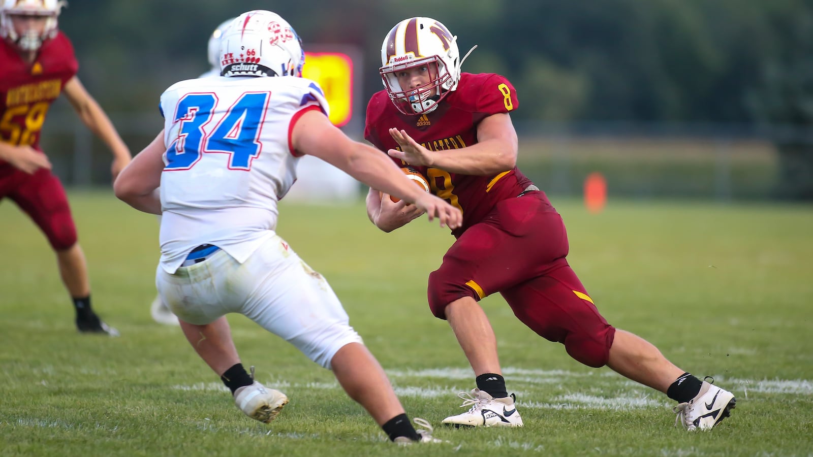 Northeastern High School junior Hunter Albright tries to stiff arm Greeneview's Jarrod Mays during their game against Greeneview on Friday night at Conover Field in Springfield. CONTRIBUTED PHOTO BY MICHAEL COOPER