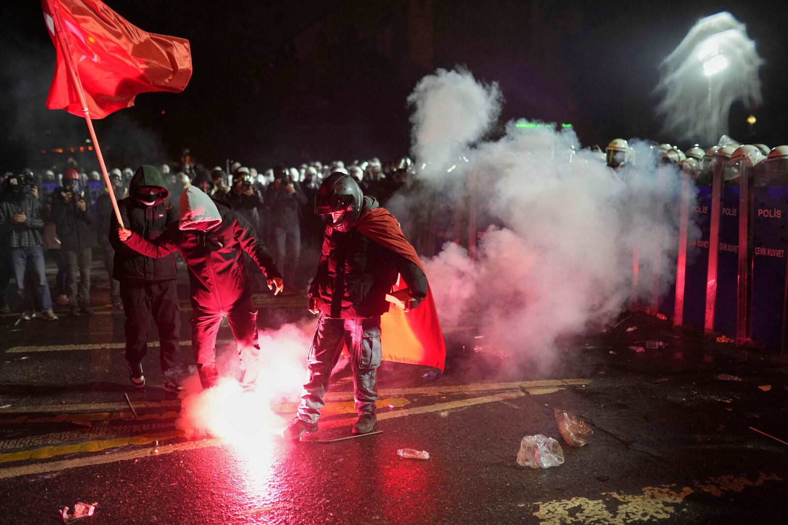 A protester kicks a firework during a protest against the arrest of Istanbul's Mayor Ekrem Imamoglu, in Istanbul, Turkey, Saturday, March 22, 2025. (AP Photo/Francisco Seco)