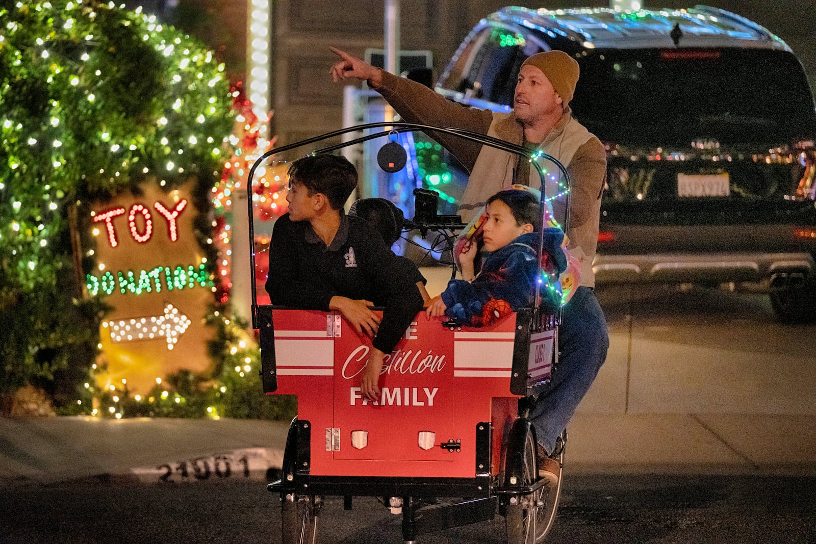 Children are wheeled through the Wakefield Winter Wonderland lighted neighborhood to view the Christmas lights in Santa Clarita, Calif. on Dec. 17, 2024. (AP Photo/Richard Vogel)