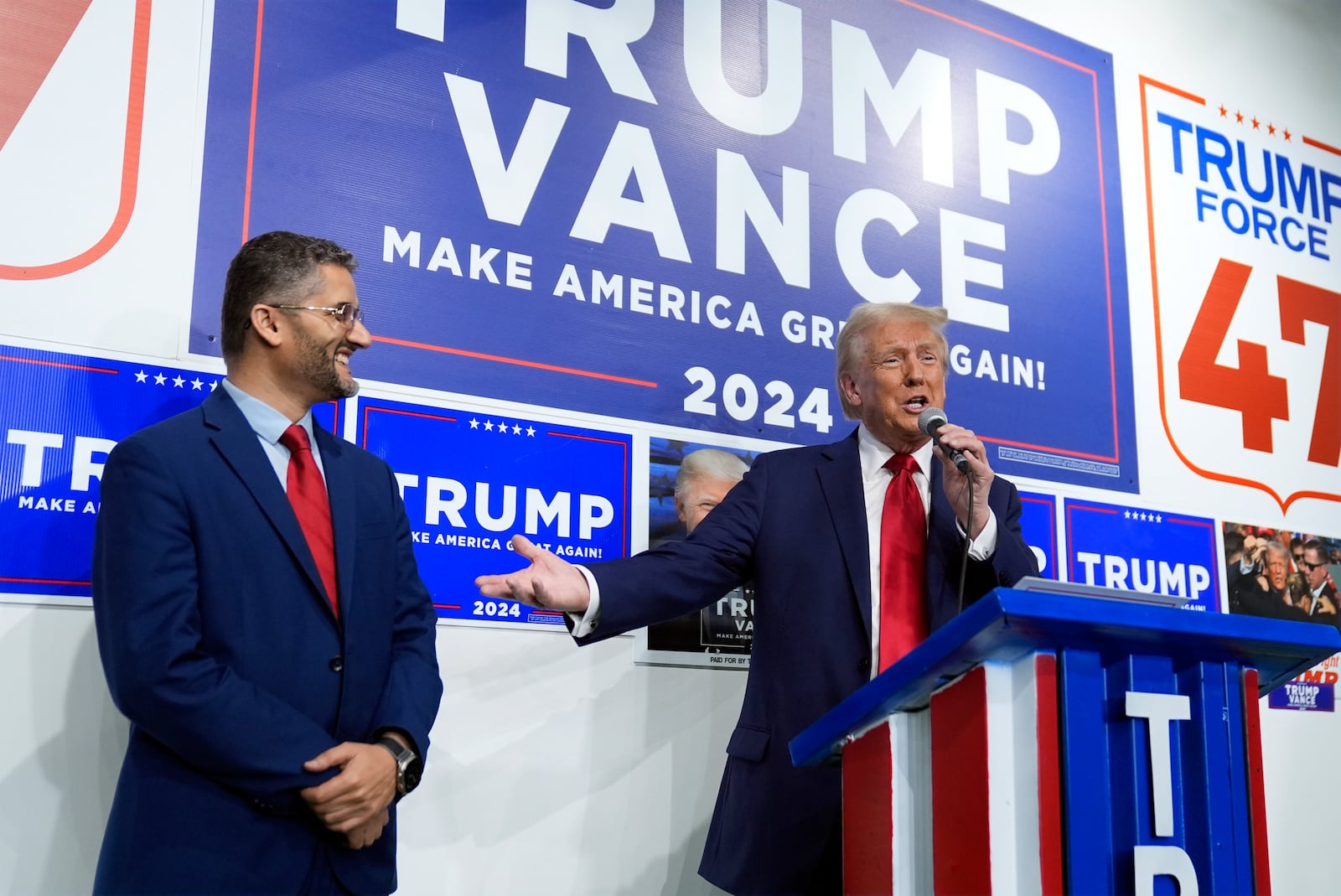 Republican presidential nominee former President Donald Trump speaks as Hamtranck Mayor Amer Ghalib listens at a campaign office, Friday, Oct. 18, 2024, in Hamtranck, Mich. (AP Photo/Evan Vucci)