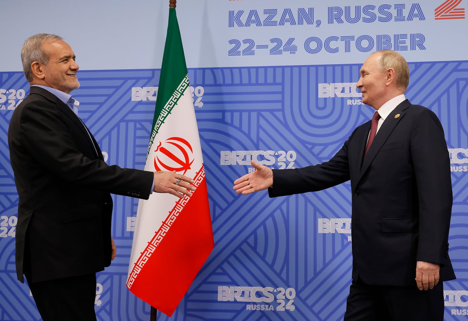 Russian President Vladimir Putin, right, and Iranian President Masoud Pezeshkian shake hands during their meeting on the sidelines of the BRICS summit in Kazan, Russia, Wednesday, Oct. 23, 2024. (Maxim Shemetov, Pool Photo via AP)