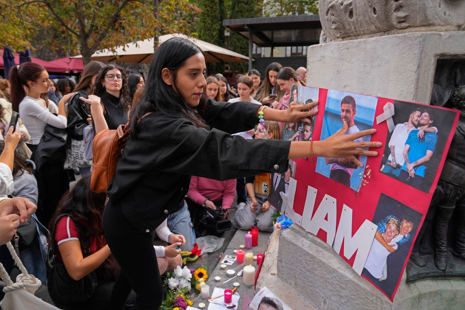 Fans of former One Direction singer Liam Payne gather in Madrid, Spain, Sunday, Oct. 20, 2024, after the British pop singer fell to his death from a hotel balcony in Argentina. (AP Photo/Paul White)