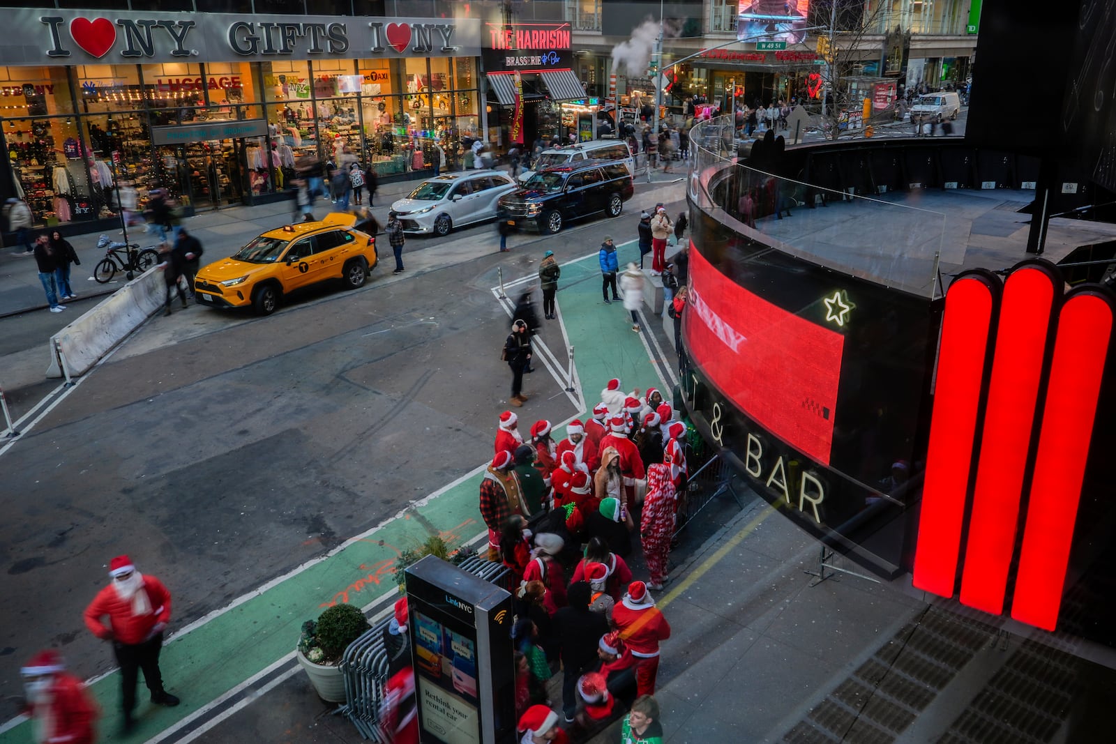 Revellers line up to enter a bar during SantaCon, Saturday, Dec. 14, 2024, in New York. (AP Photo/Julia Demaree Nikhinson)