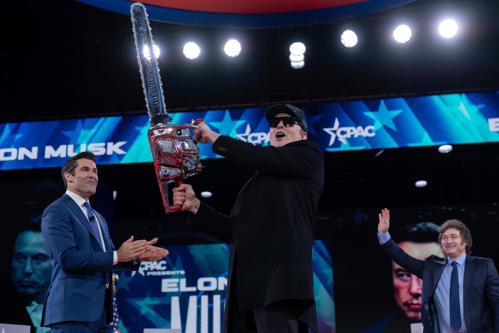 Elon Musk, left, receives a chainsaw from Argentina's President Javier Milei, right, as they arrive speaks at the Conservative Political Action Conference, CPAC, at the Gaylord National Resort & Convention Center, Thursday, Feb. 20, 2025, in Oxon Hill, Md. (AP Photo/Jose Luis Magana)