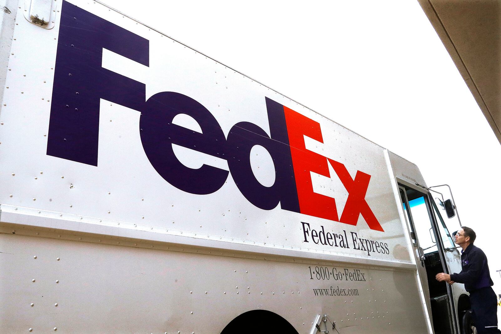 FILE - In this photo taken on Thursday, Dec. 18, 2014, a Federal Express delivery truck driver returns to his truck after delivering a package to a business, in Springfield, Ill. (AP Photo/Seth Perlman, File)