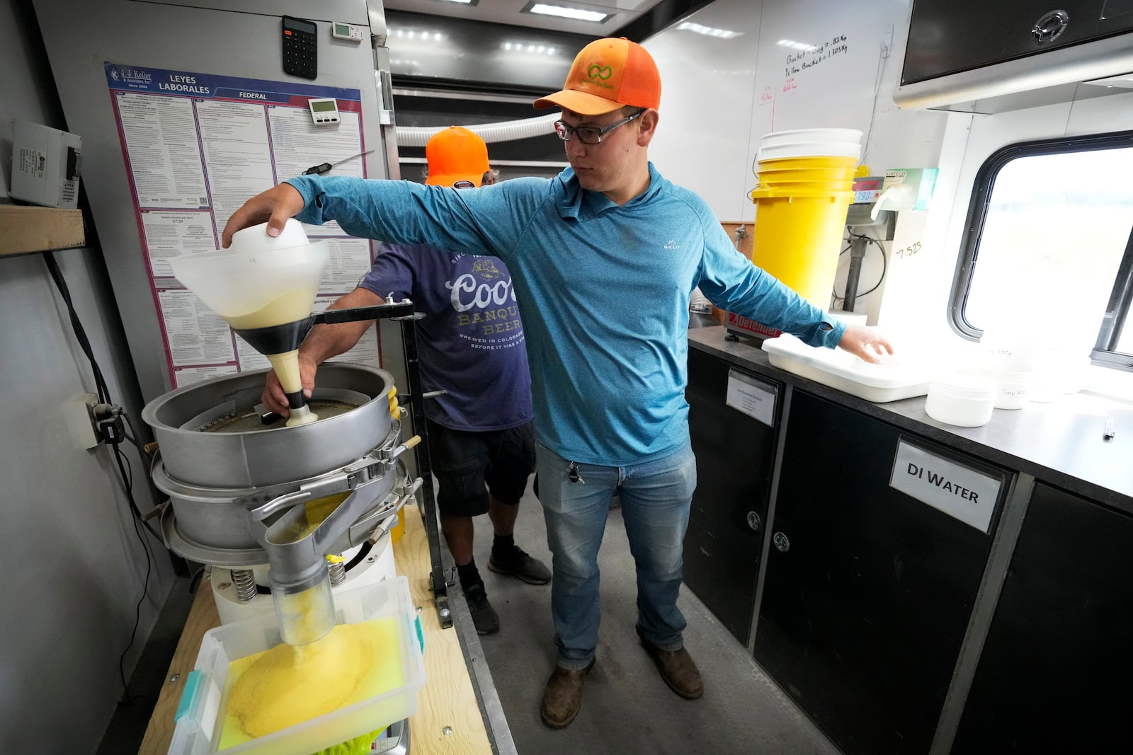 Dylan Riedemann sifts pollen after it was removed from corn in a field, Thursday, Aug. 22, 2024, near Ames, Iowa. (AP Photo/Charlie Neibergall)