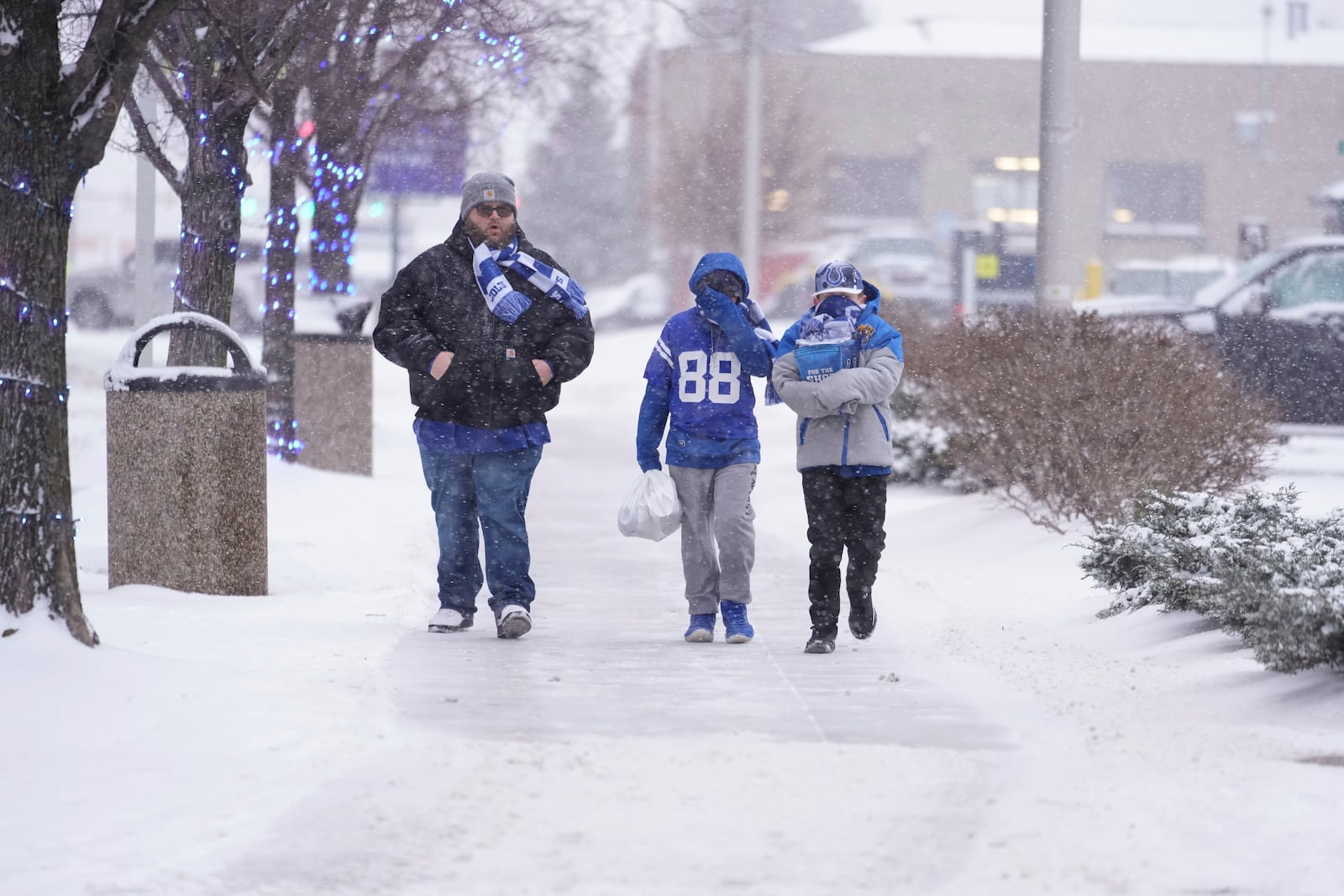 Indianapolis Colts fans walk in the falling snow after an NFL football game between the Indianapolis Colts and the Jacksonville Jaguars, Sunday, Jan. 5, 2025, in Indianapolis. The Colts won 26-23 in overtime. (AP Photo/Michael Conroy)