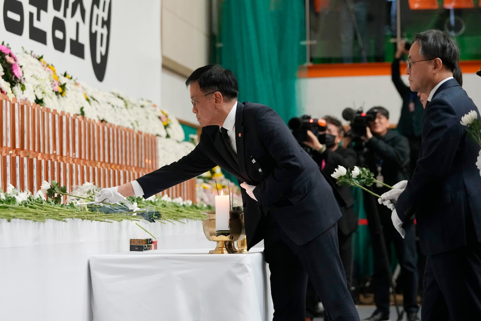 South Korea's acting President Choi Sang-mok places a flower for the victims on a plane which skidded off a runway and burst into flames, at a memorial altar at Muan sport park in Muan, South Korea, Monday, Dec. 30, 2024. (AP Photo/Ahn Young-joon)