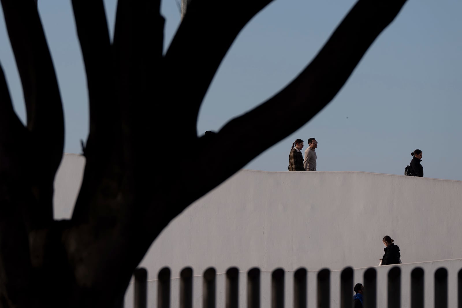 People cross the border into Mexico from the United States, Monday, Jan. 20, 2025, in Tijuana, Mexico. (AP Photo/Gregory Bull)