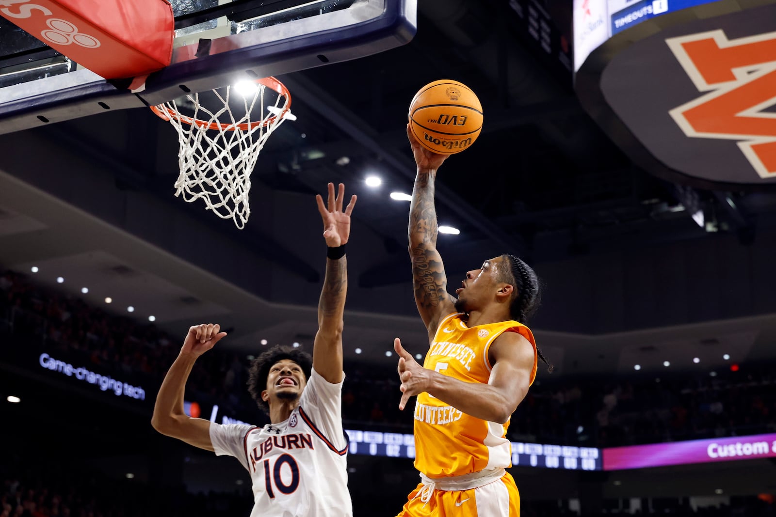 Tennessee guard Zakai Zeigler, right, goes up to shoot over Auburn guard Chad Baker-Mazara (10) during the first half of an NCAA college basketball game, Saturday, Jan. 25, 2025, in Auburn. (AP Photo/Butch Dill)