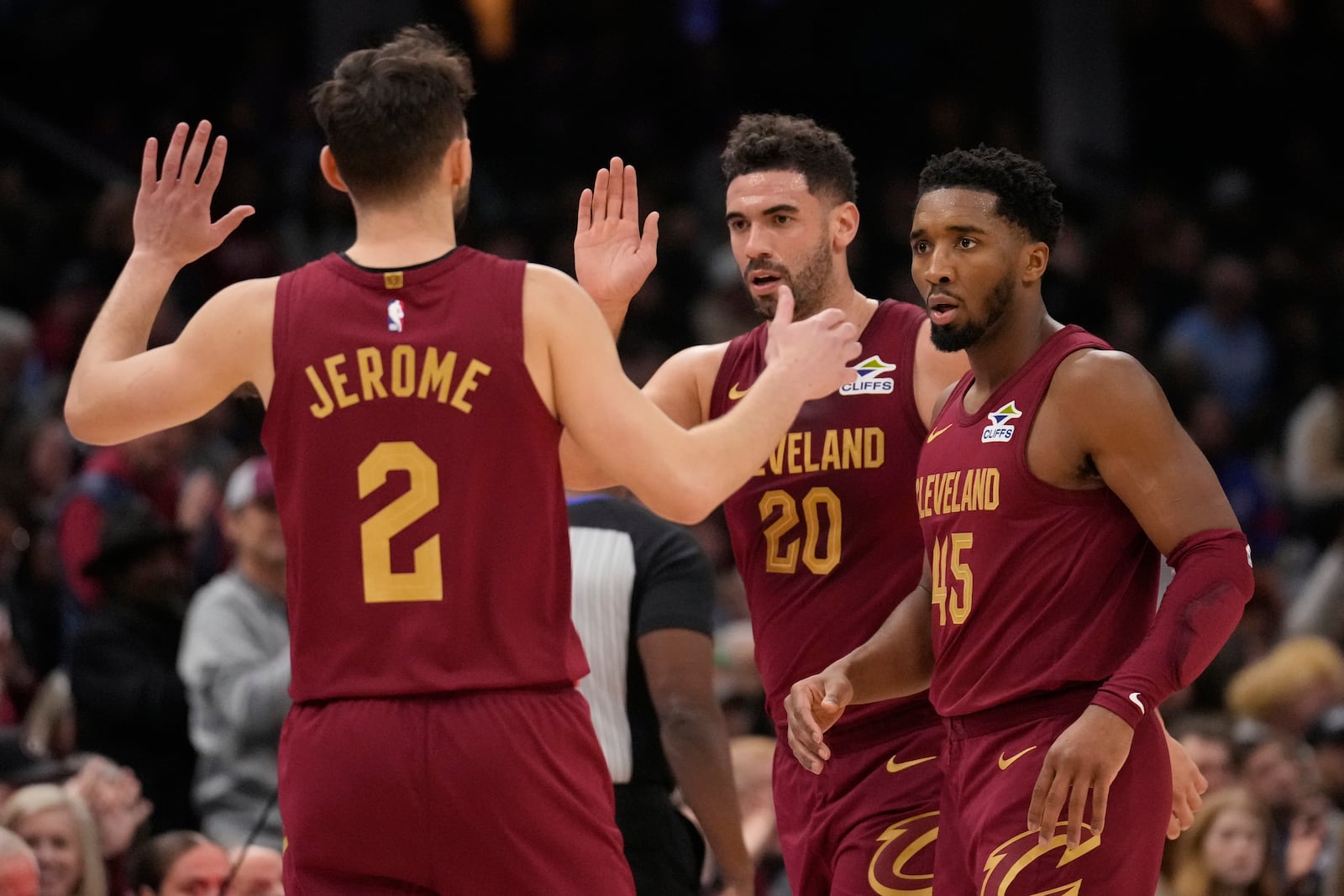 Cleveland Cavaliers guard Ty Jerome (2), forward Georges Niang (20) and guard Donovan Mitchell (45) celebrate in the first half of an NBA basketball game against the Boston Celtics, Sunday, Dec. 1, 2024, in Cleveland. (AP Photo/Sue Ogrocki)