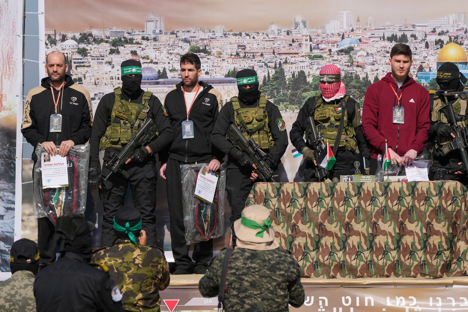 Israeli hostages Iair Horn, 46, left, Sagui Dekel Chen, 36, center left, and Alexander Troufanov, 29, right, are escorted by Hamas and islamic Jihad fighters as they are handed over to the Red Cross in Khan Younis, Gaza Strip, Saturday, Feb. 15, 2025. (AP Photo/Abdel Kareem Hana)