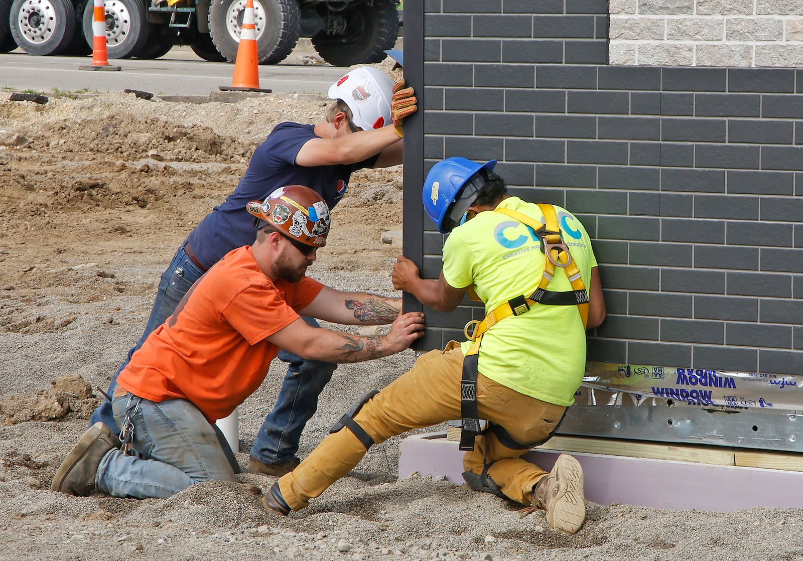 Workers push the new 7 Brew drive-thru stand into place as it's lowered into place on East Main Street on May 24, 2024. The city of Springfield says local income taxes paid by workers and businesses are expected to grow by 2.2% in 2025. BILL LACKEY/STAFF