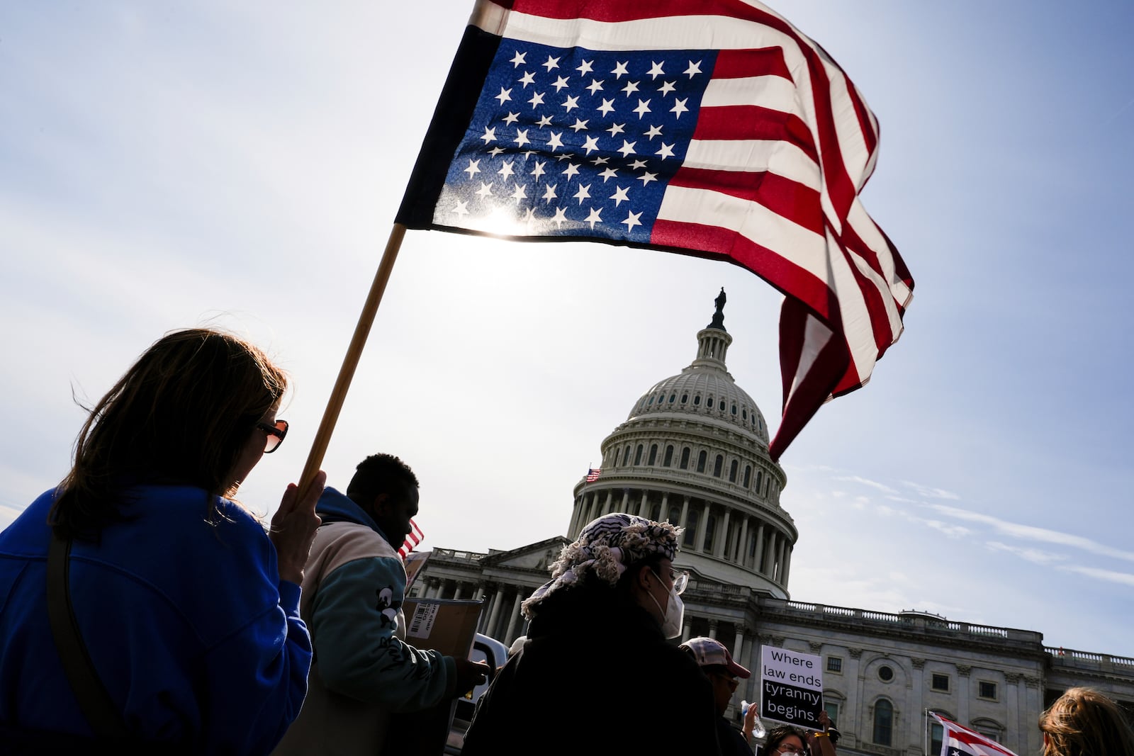 A protester waves an upside down American flag in front of the Capitol, Tuesday, March 4, 2025, in Washington. (AP Photo/Julia Demaree Nikhinson)