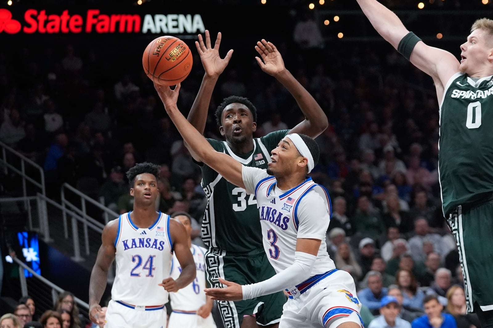 Kansas guard Dajuan Harris Jr. (3) shoots as Michigan State forward Xavier Booker (34) defends during the first half of an NCAA college basketball game, Tuesday, Nov. 12, 2024, in Atlanta. (AP Photo/John Bazemore )