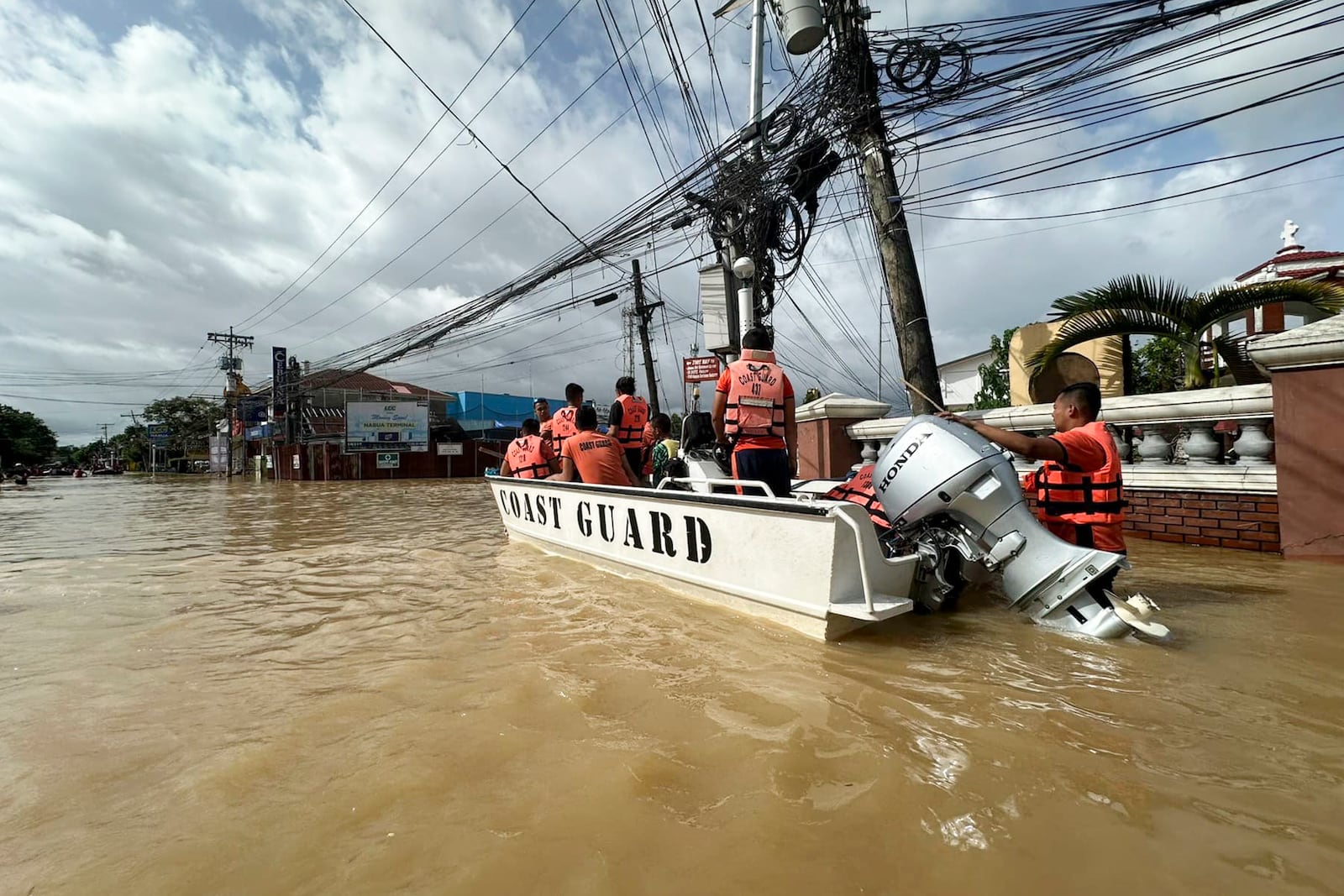 In this photo provided by the Philippine Coast Guard, rescuers ride a boat around the flooded town of Nabua, Camarines Sur, Philippines on Friday Oct. 25, 2024. (Philippine Coast Guard via AP)