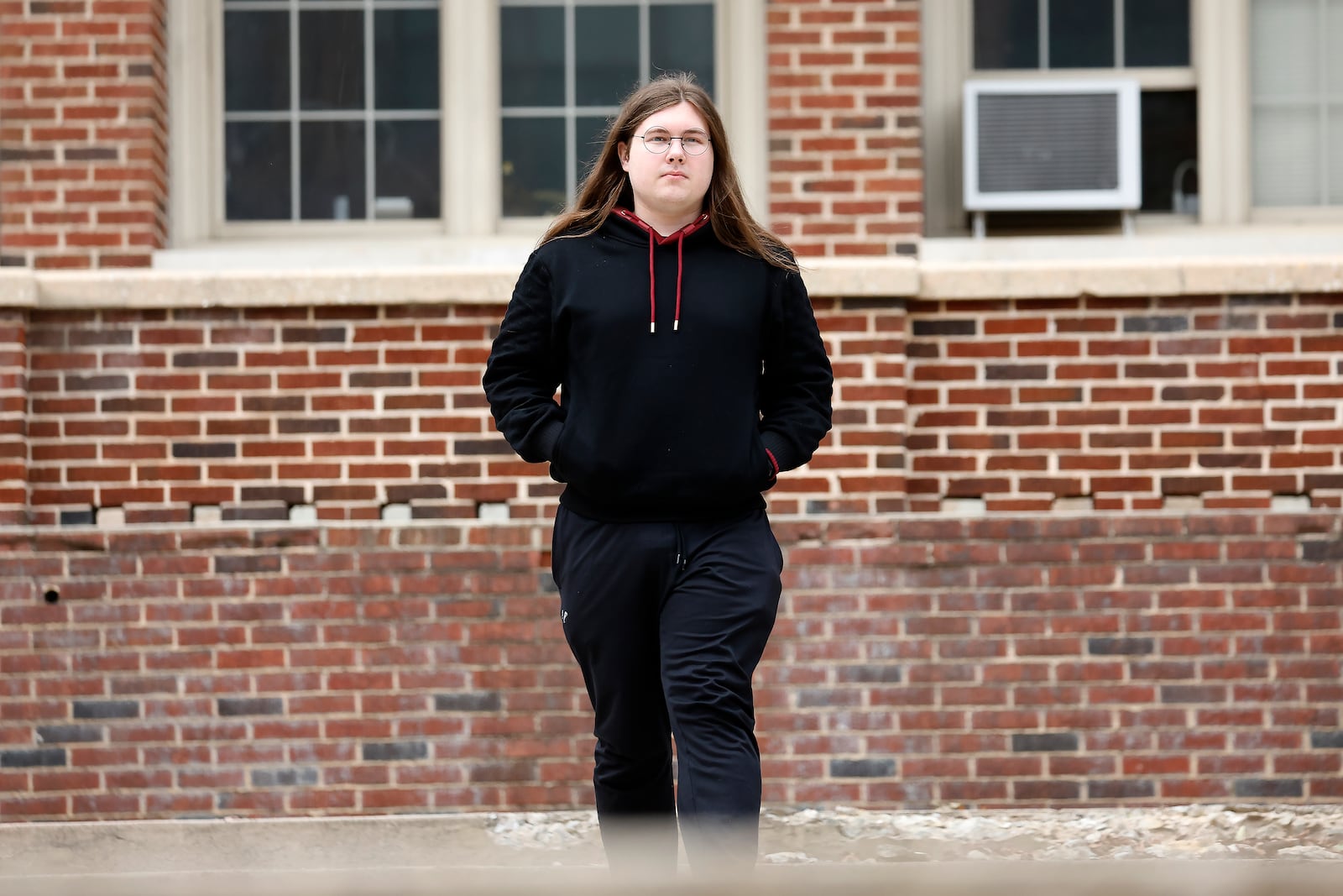 Glenn Thompson, a Durham School of the Arts graduate, poses in front of the school in Durham, N.C., Monday, March 10, 2025. (AP Photo/Karl DeBlaker)