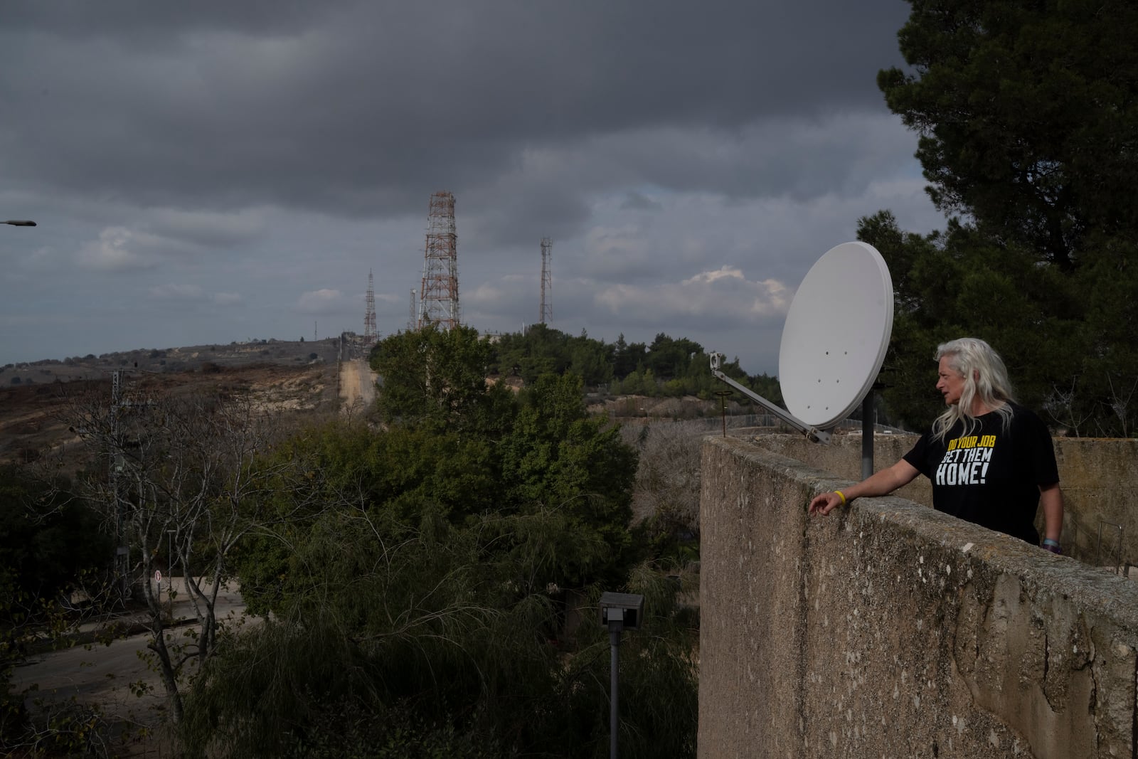 Orna Zilberstine looks at the direction of the Israeli-Lebanese border as she stands on a building in the Kibbutz Manara, northern Israel, Thursday, Nov. 28, 2024. (AP Photo/Leo Correa)